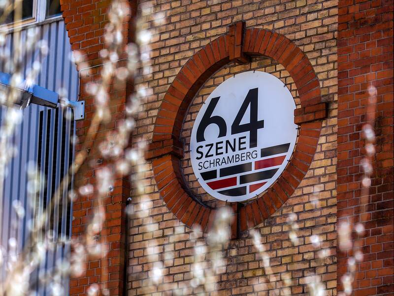 Das Logo der Szene 64 in einer Rotunde des Gebäudes